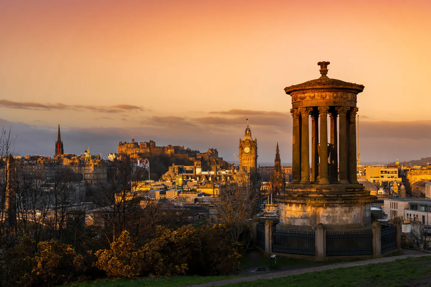 The Dugald Stewart Monument on Calton Hill with Edinburgh Castle and the Old Town skyline at sunset
