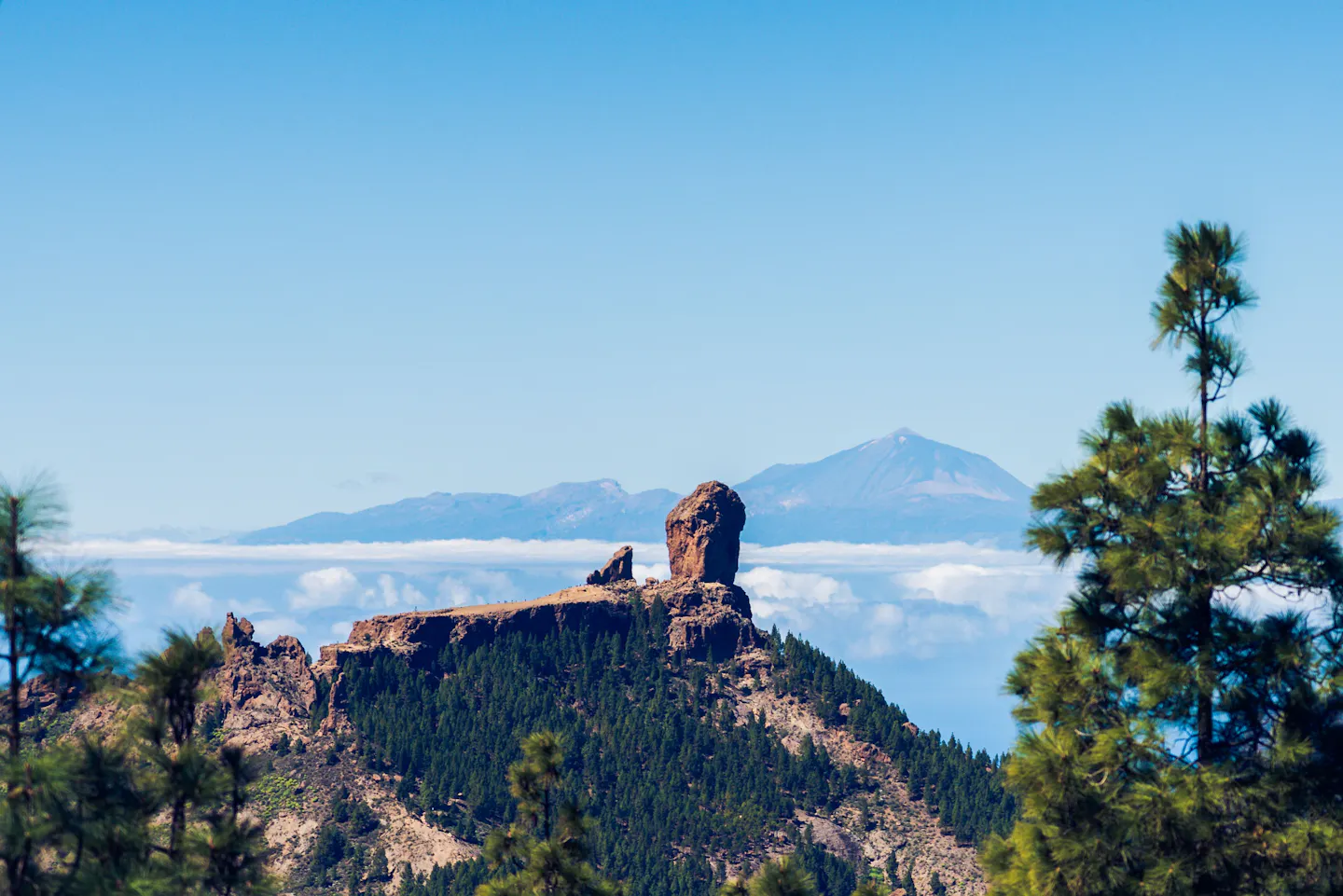 The Roque Nublo rock on Gran Canaria with Mount Teide on Tenerife on the horizon beyond