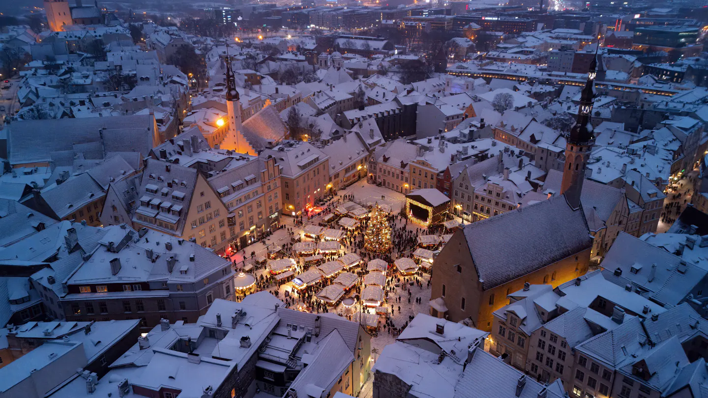 Tallinn’s Christmas market glowing in the snow-covered Town Hall Square at dusk