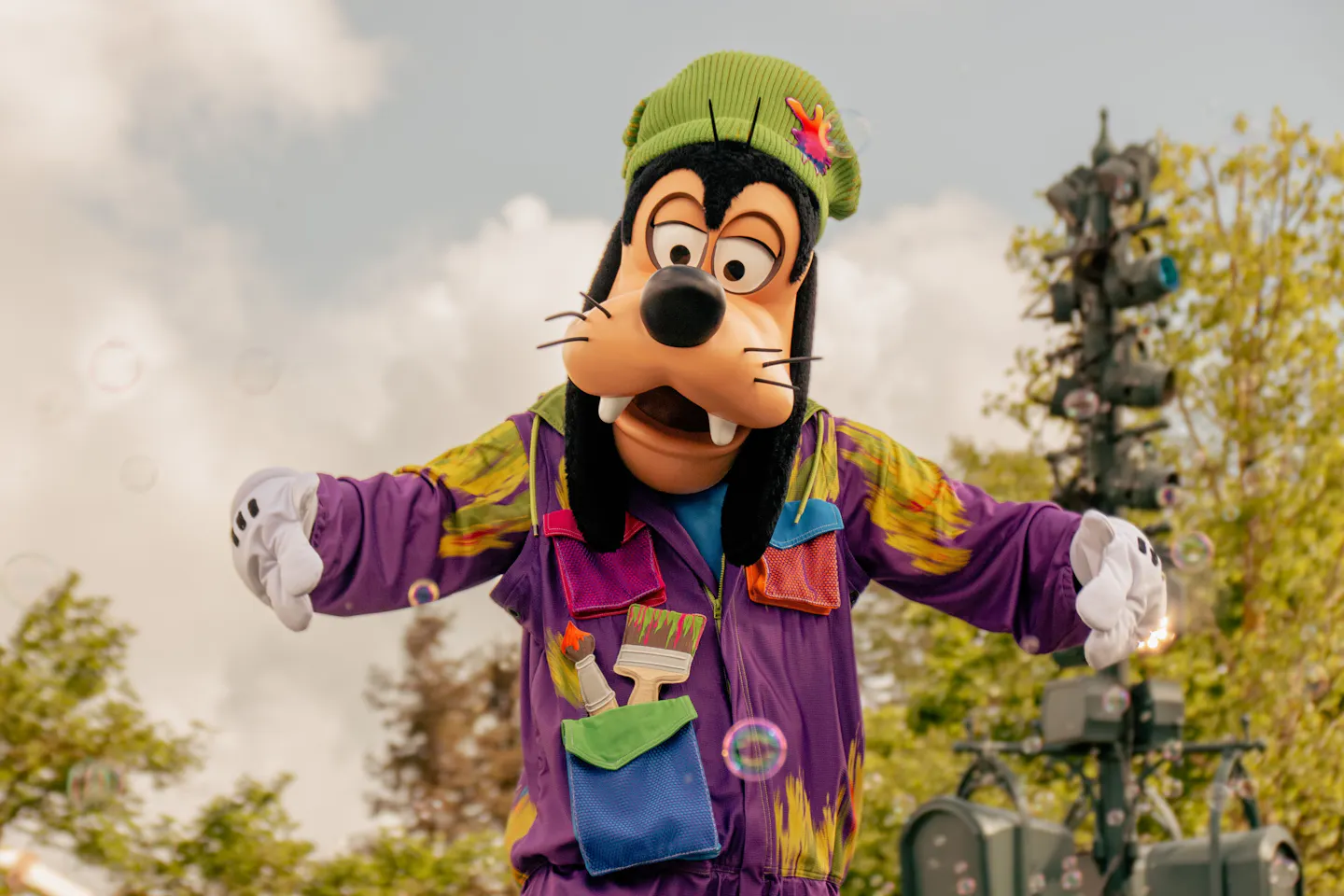 Goofy in a colorful painter's outfit greeting guests during a show at Disneyland Paris