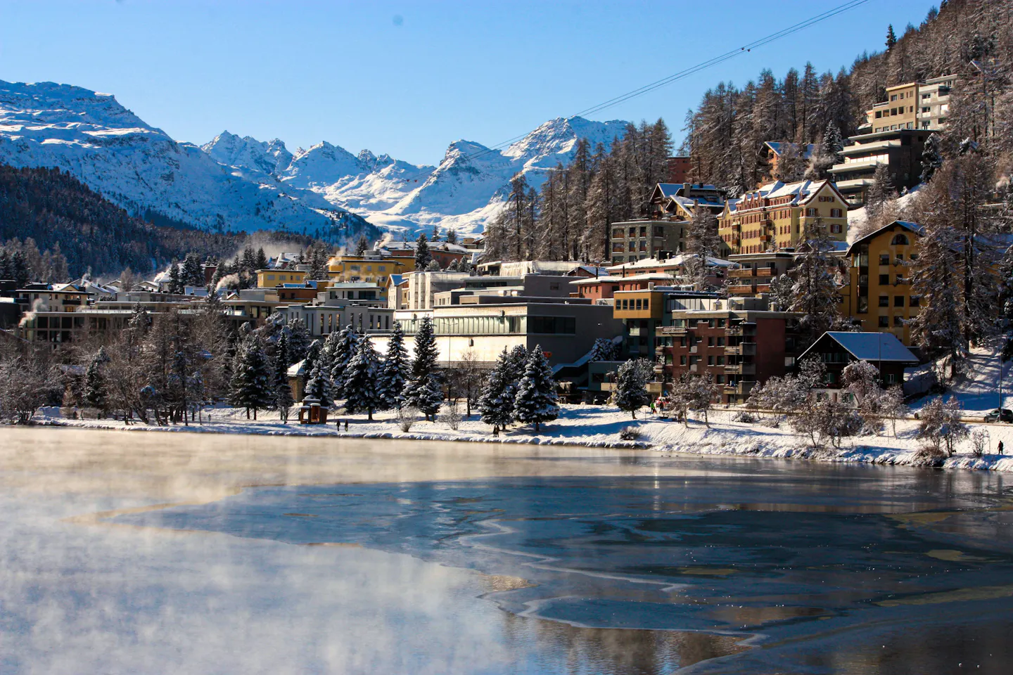 St. Moritz beside its frozen lake, framed by snowy Alpine mountains