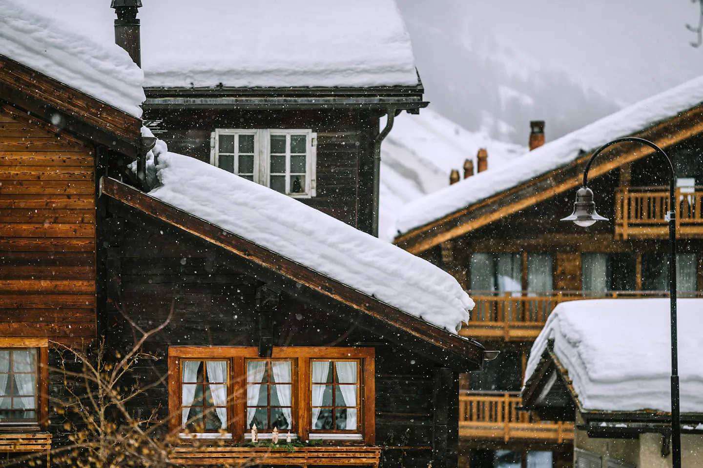 Snow-covered timber chalets in Gstaad, Switzerland, on a winter day