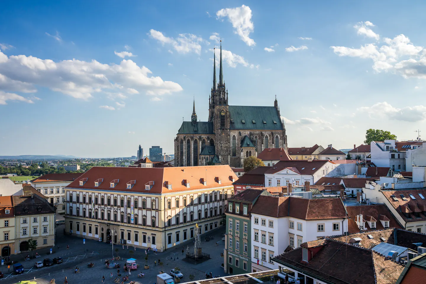 The twin Gothic spires of the Cathedral of St Peter and Paul above the orange rooftops of Brno