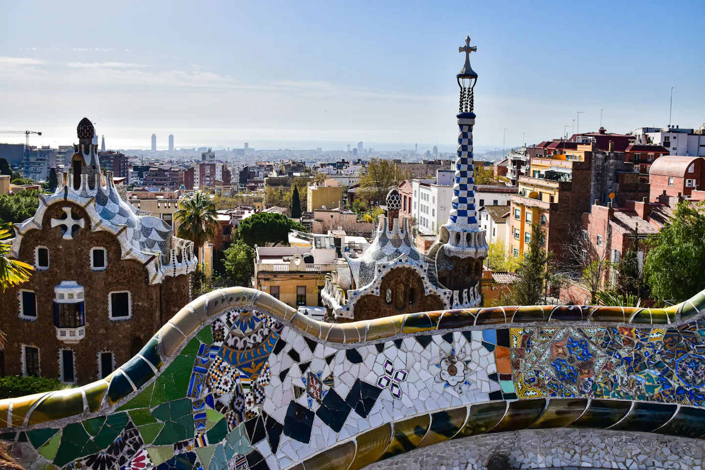 The serpentine mosaic bench at Park Guell above the tiled pavilions and Barcelona rooftops