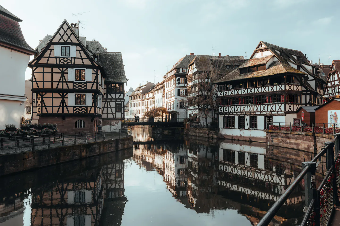 Half-timbered houses of Strasbourg's Petite France reflected in a still canal on a winter day