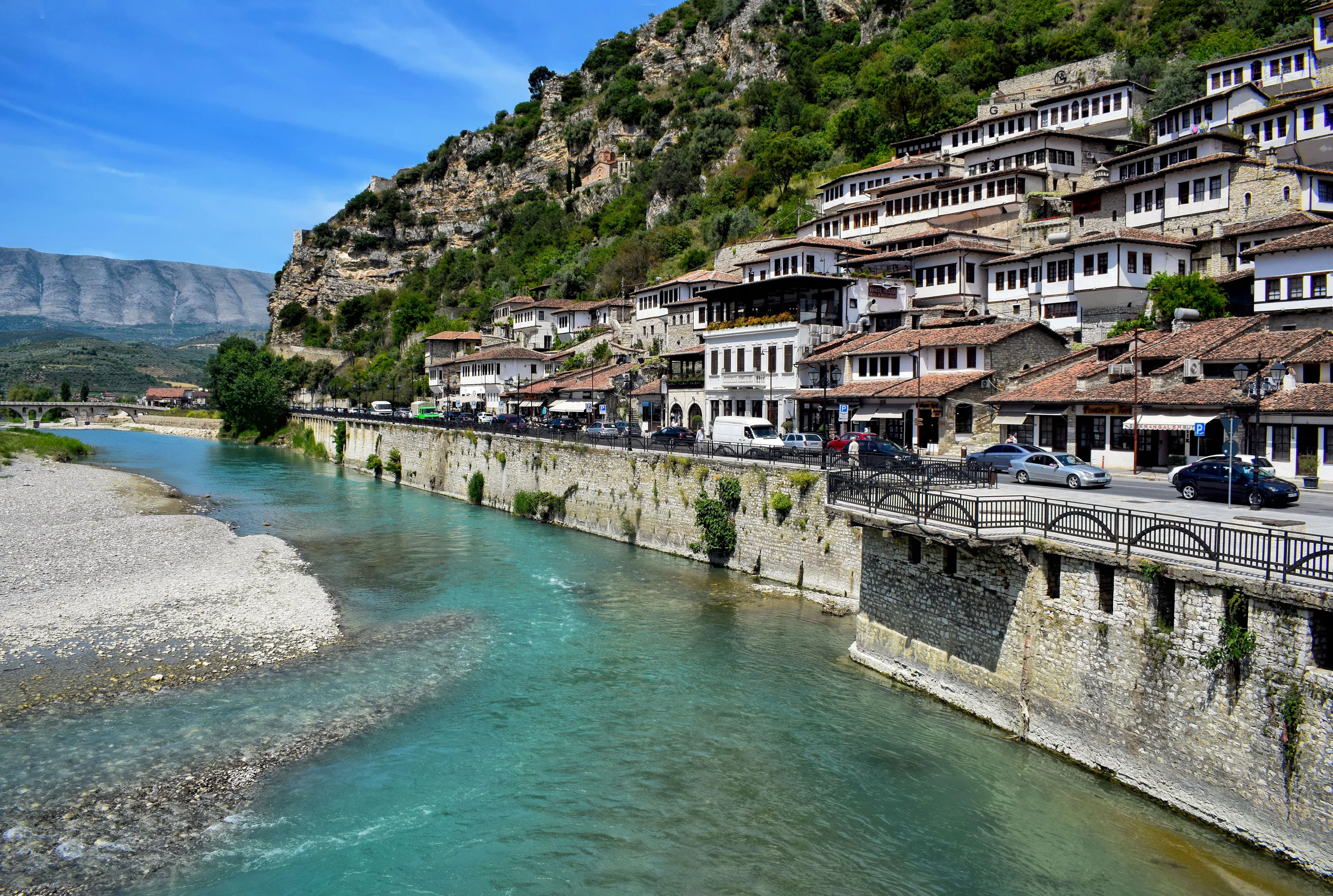 Ottoman houses stacked on the hillside above the turquoise Osum River in Berat, Albania