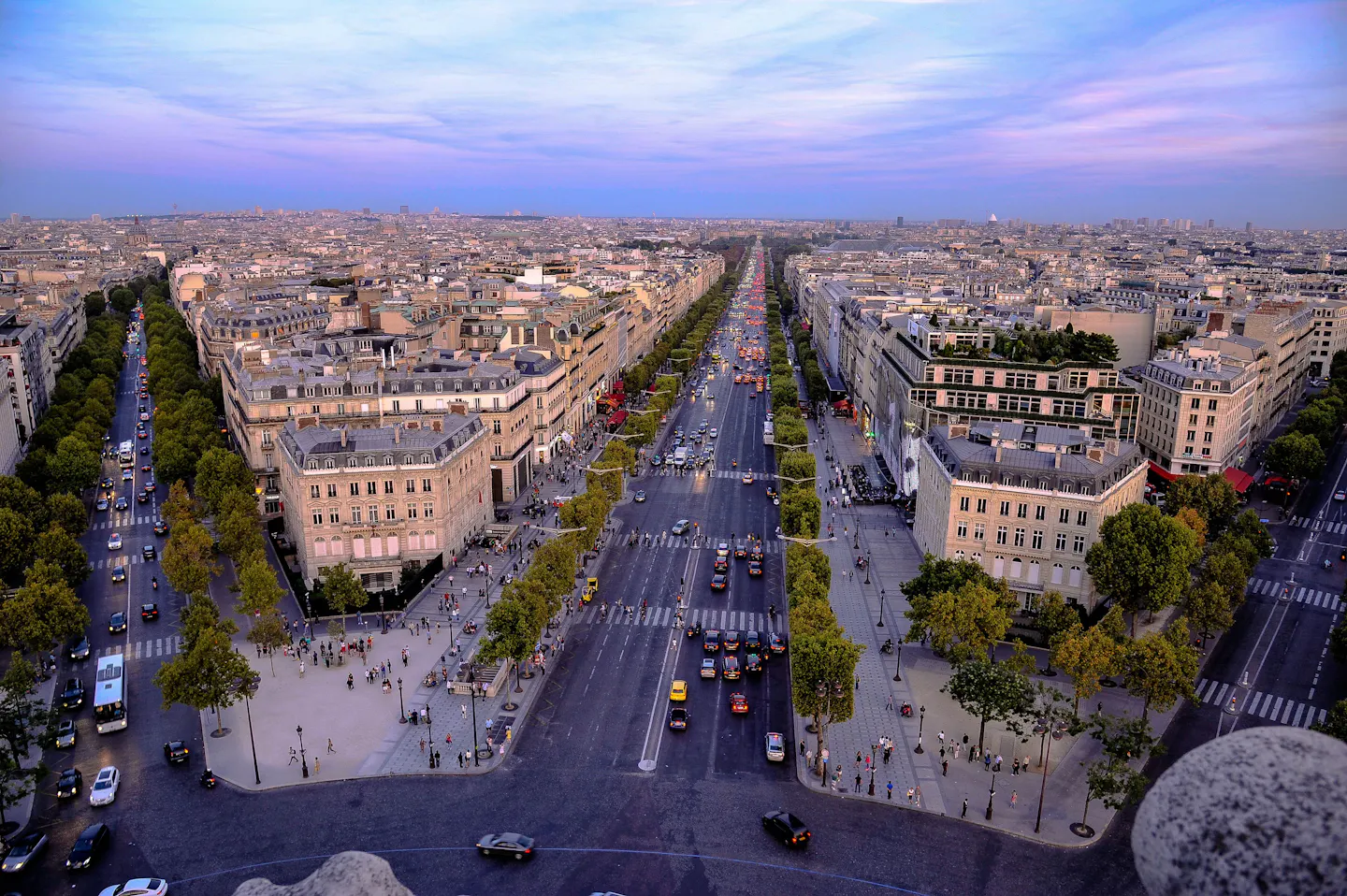 The Avenue des Champs-Elysees and the rooftops of western Paris seen from above at dusk