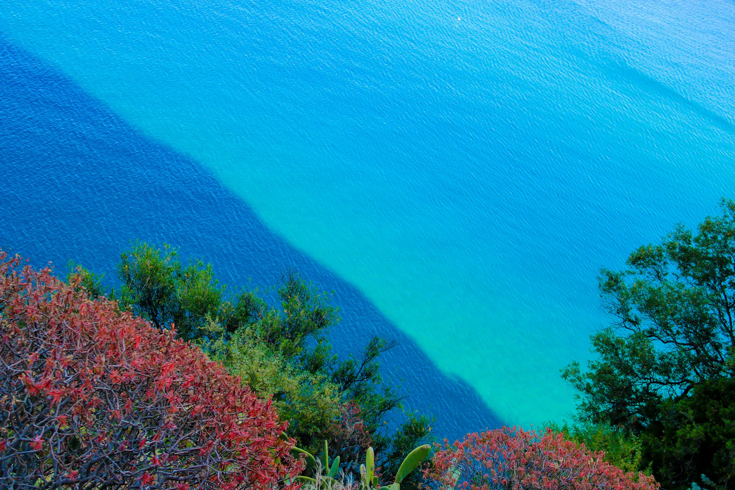 Turquoise water along a rocky stretch of the Italian coast seen from above