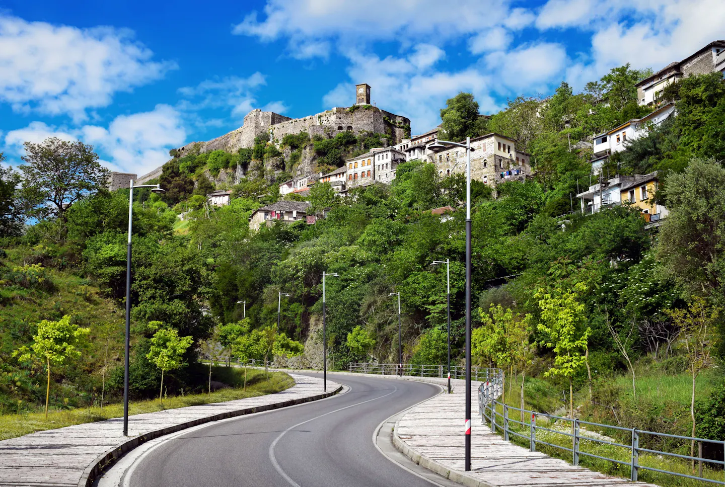 Gjirokastër Castle above the stone houses and green hillside of the old town in Albania