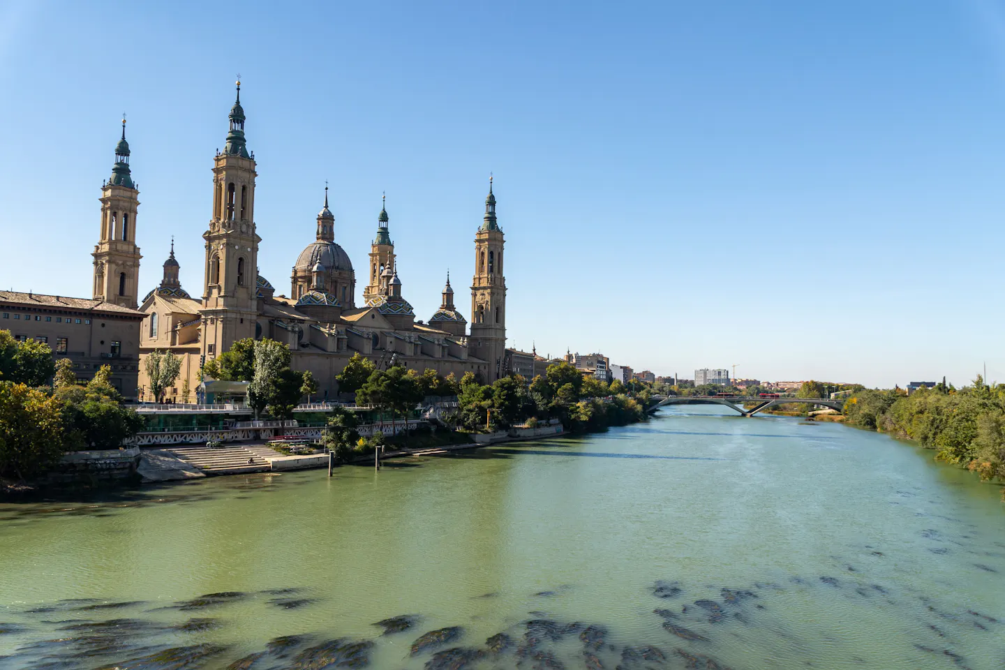 The towers and tiled domes of the Basilica del Pilar rising above the Ebro river in Zaragoza