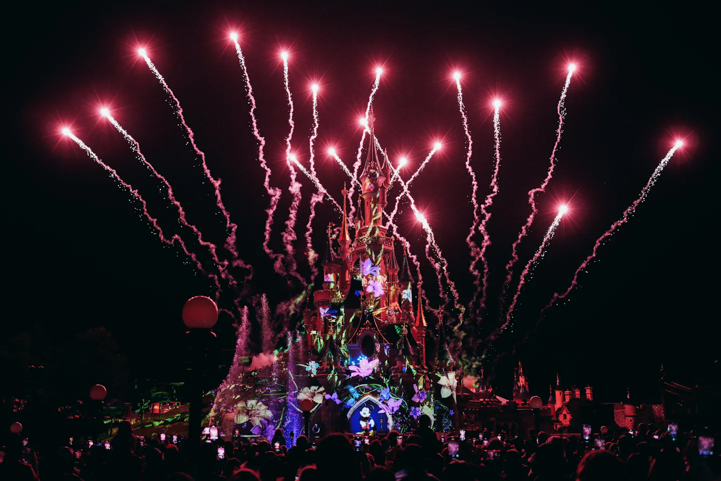 Fireworks and projections on Sleeping Beauty Castle during the nighttime show at Disneyland Paris