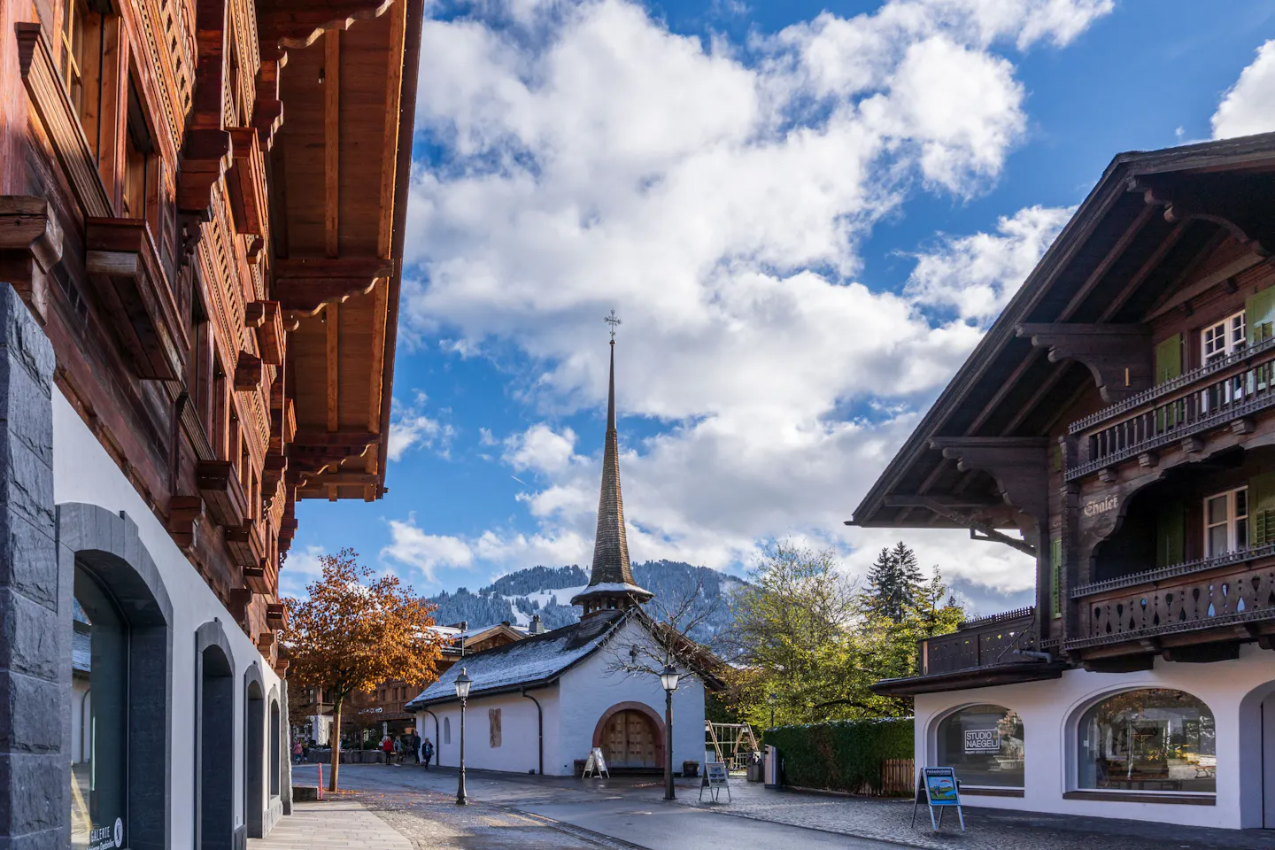 A street of chalet-style buildings and a small church in Gstaad, Switzerland