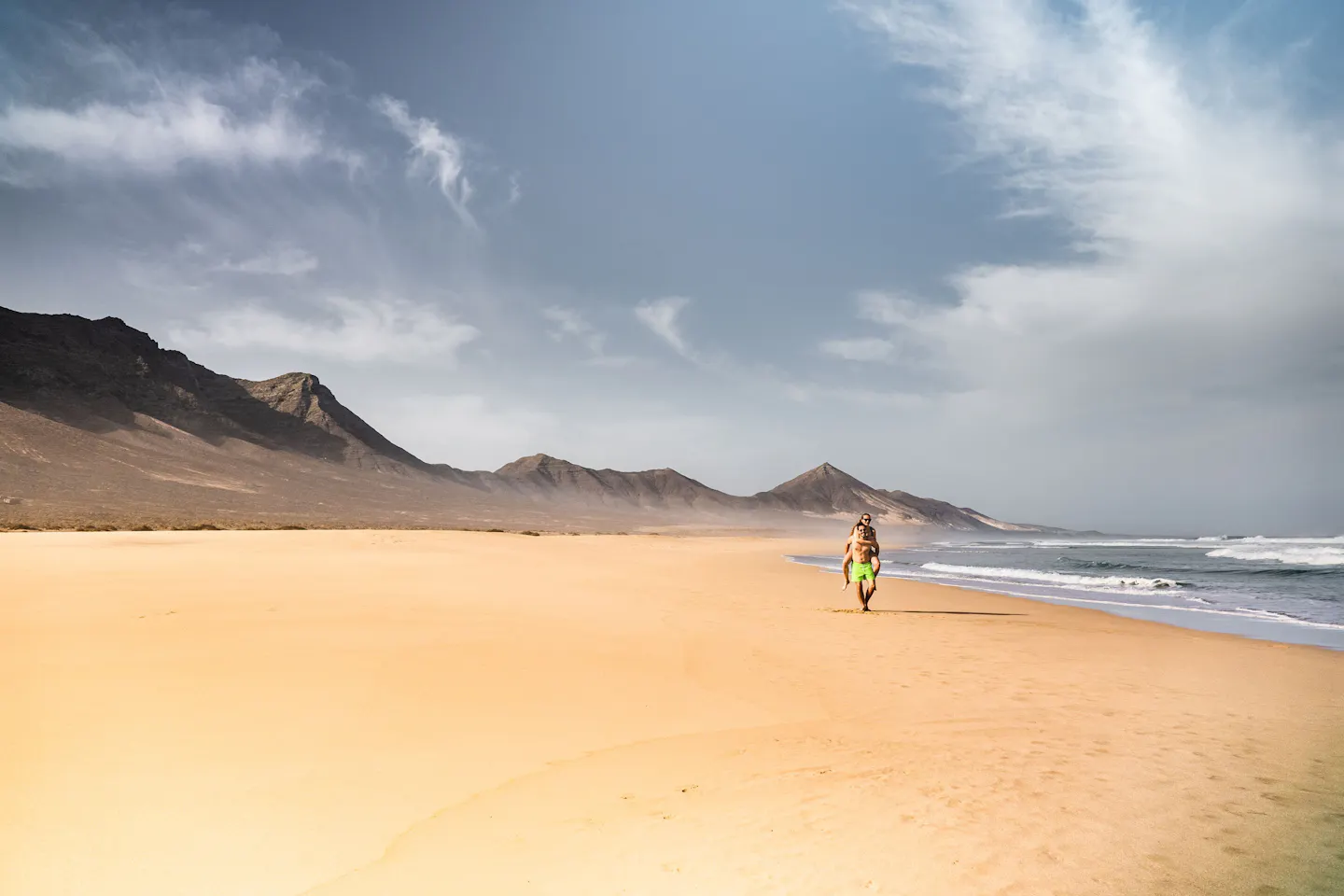 Fuerteventura’s wide golden beach beneath the island’s arid volcanic mountains