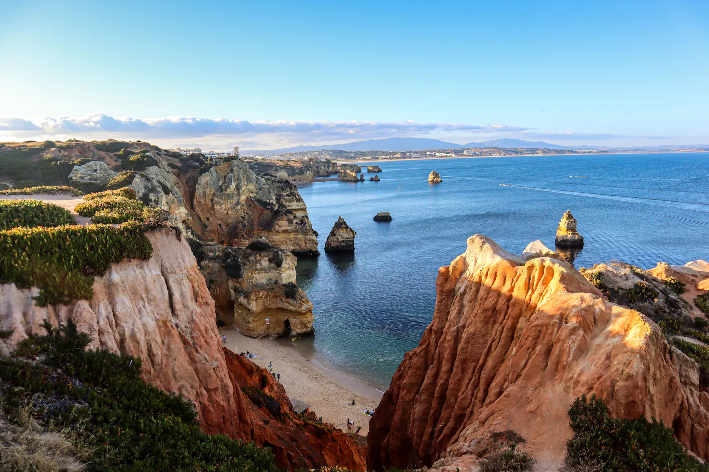 Golden sandstone cliffs and sea stacks along the Atlantic coast of the Algarve in warm light