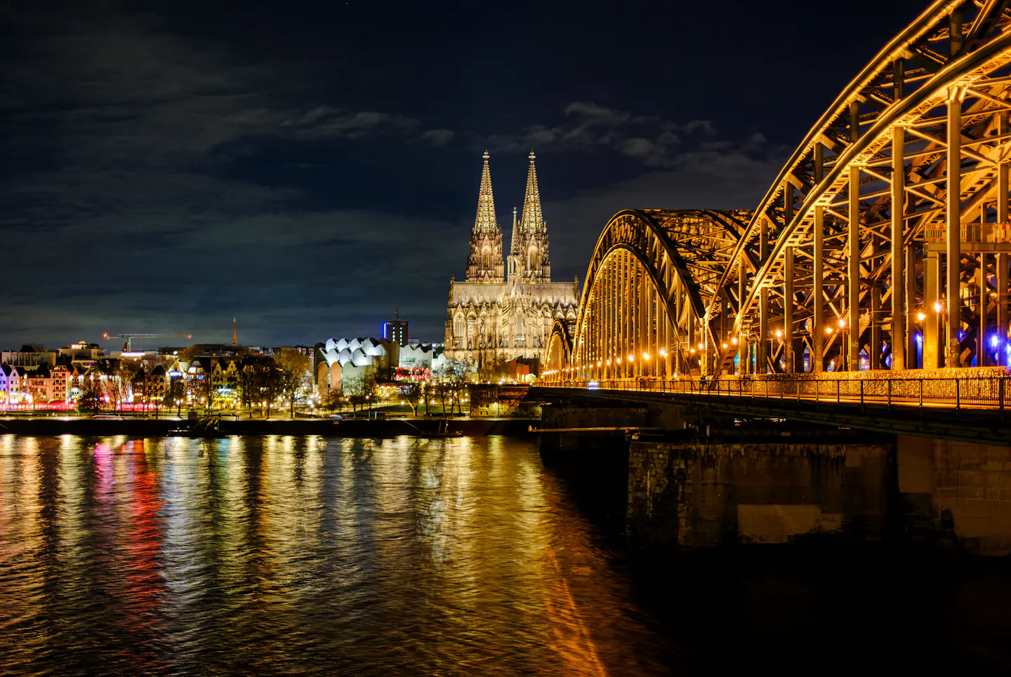 Cologne Cathedral and the lit Hohenzollern Bridge reflected in the Rhine at night