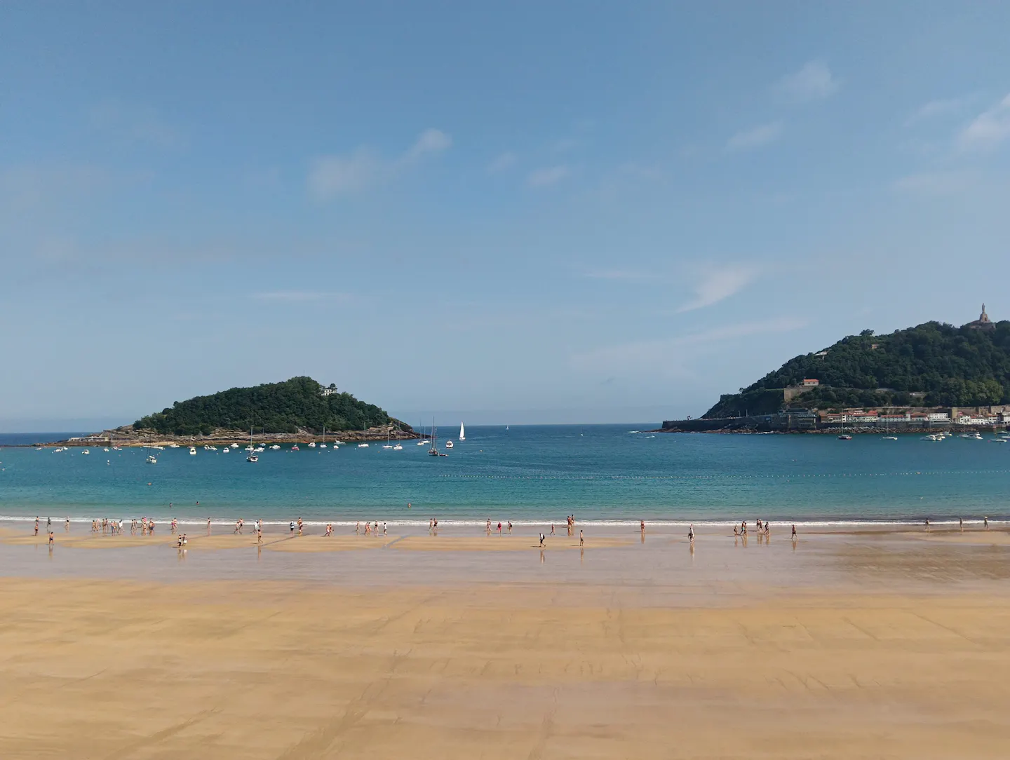 Sheltered bay with sailboats and a small island on the Basque coast at San Sebastián
