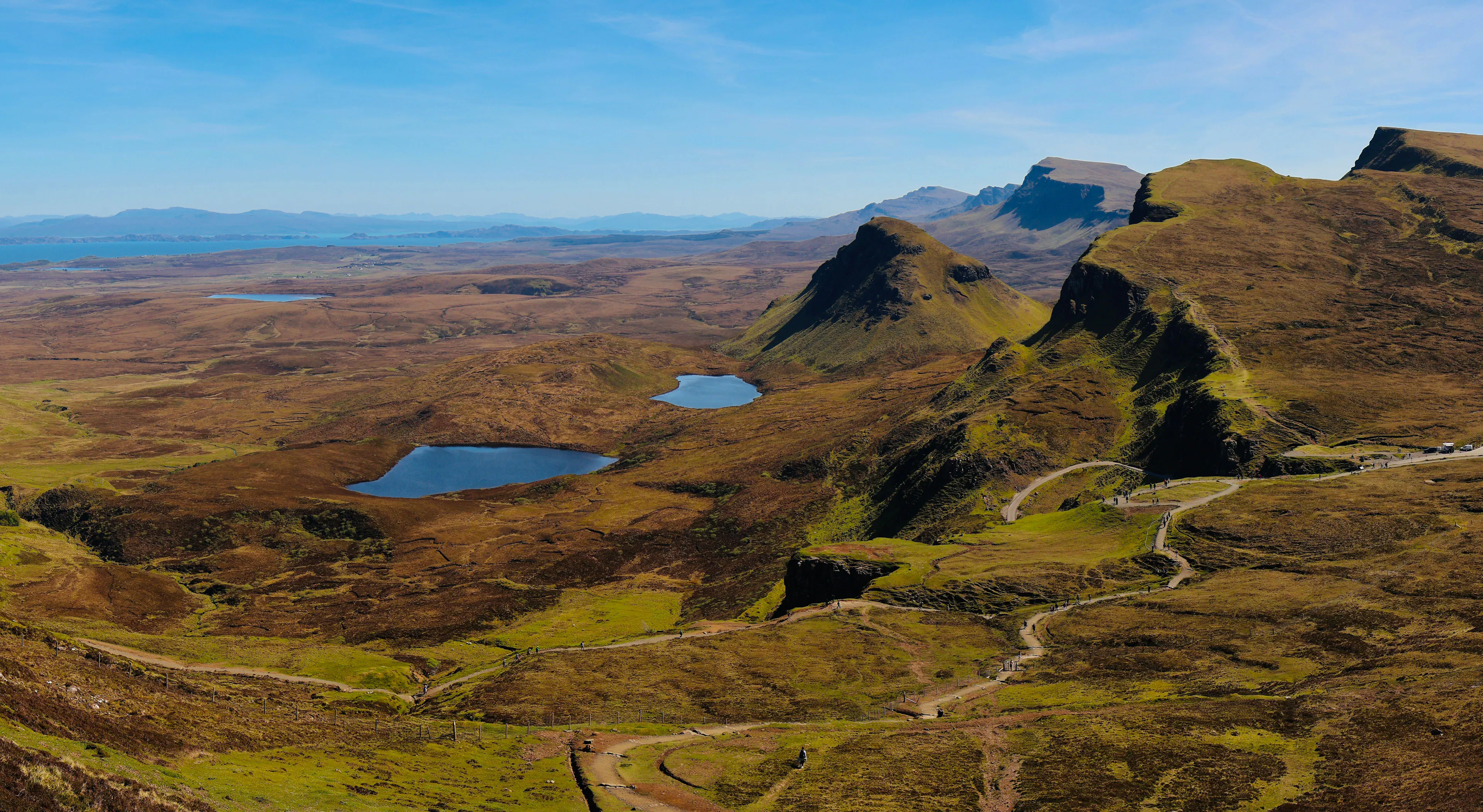 The Quiraing's cliffs and small lochs on the Isle of Skye under a clear blue sky