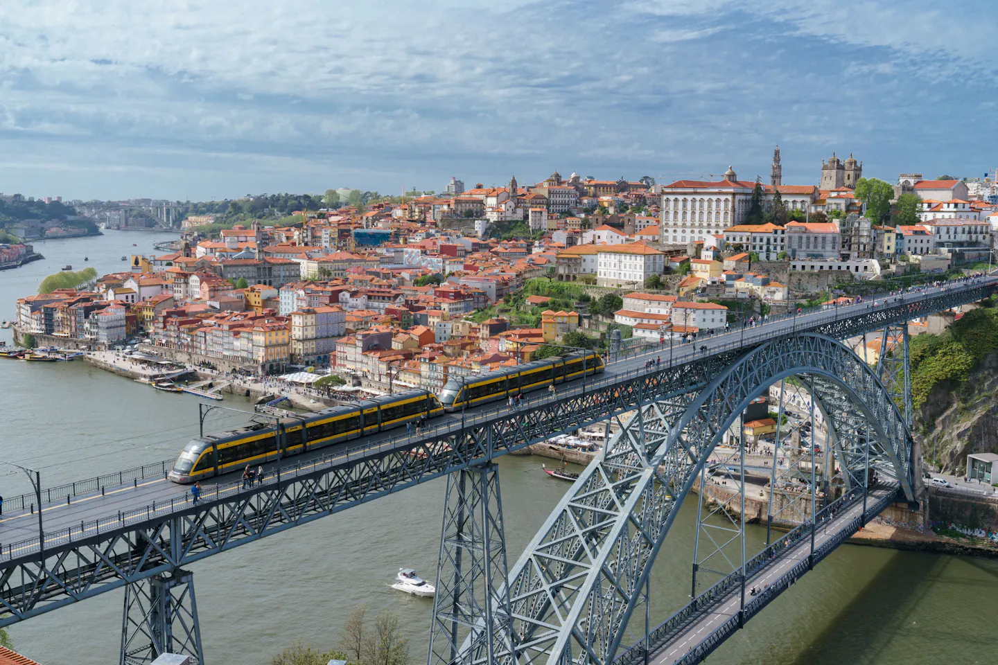 Porto's Ribeira waterfront and the Dom Luís I Bridge, with a metro train crossing the Douro River