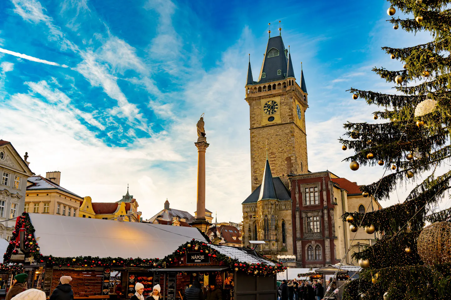 Prague Old Town Square winter market beneath the Gothic tower and Christmas tree