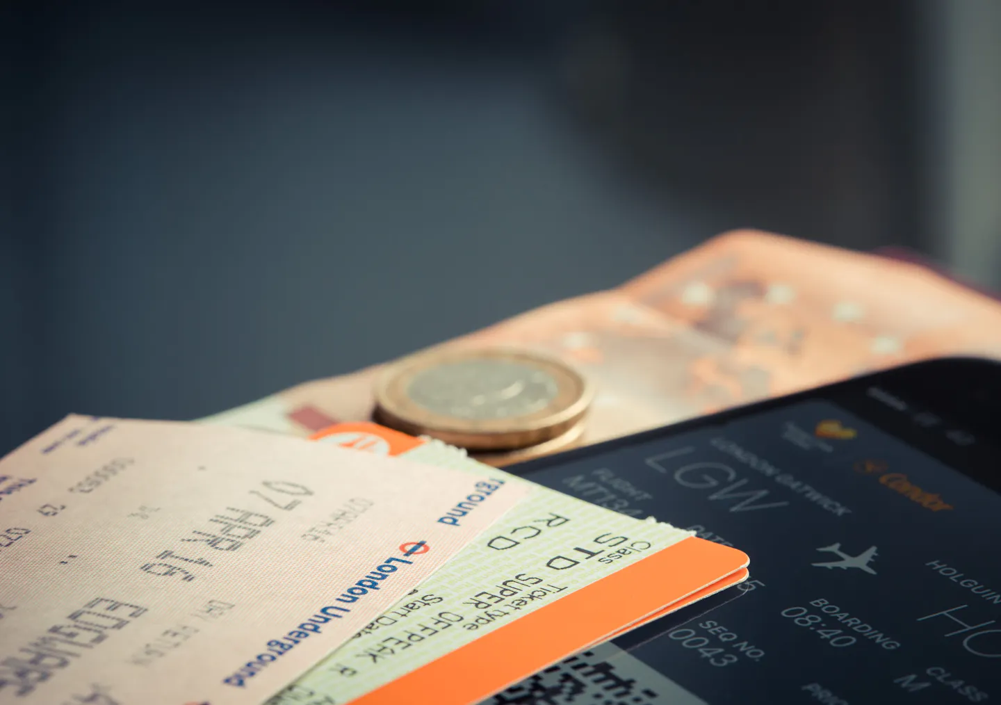 Airline tickets and coins laid out for planning travel costs