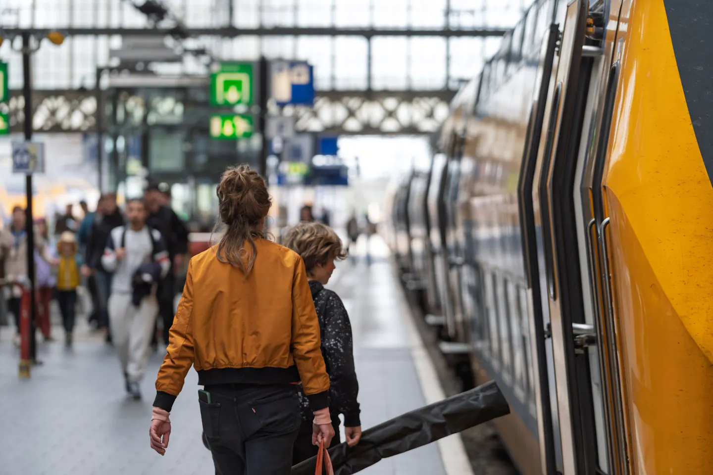 Travelers boarding a train at a busy station platform