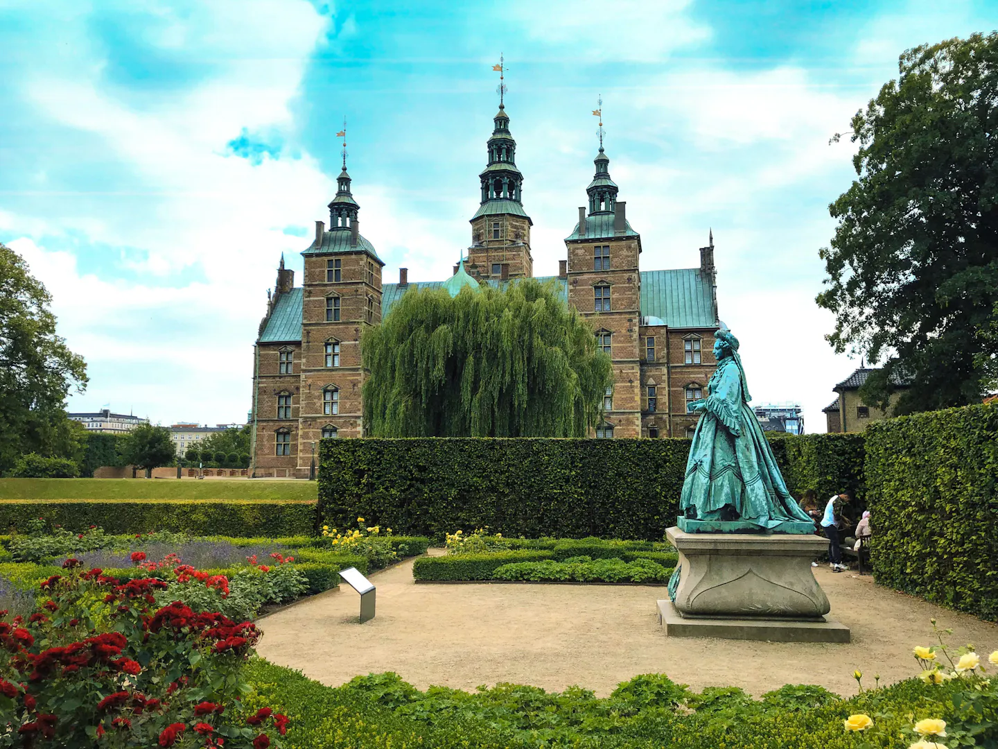 Rosenborg Castle behind a weeping willow and red flowerbeds in the King's Garden, Copenhagen