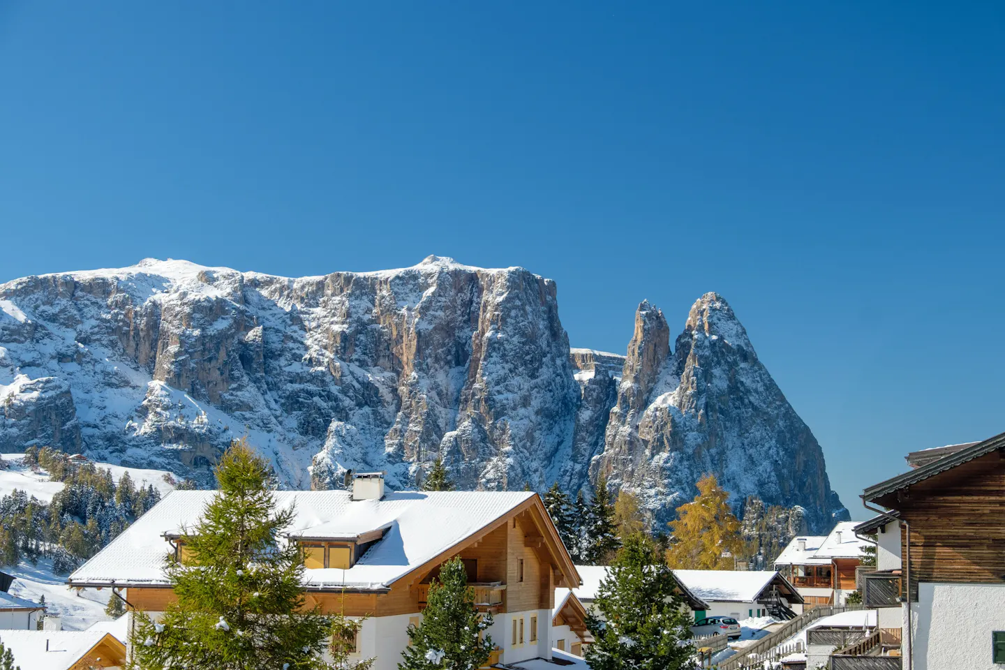 Snow-covered South Tyrolean village beneath the sunlit Dolomites in winter