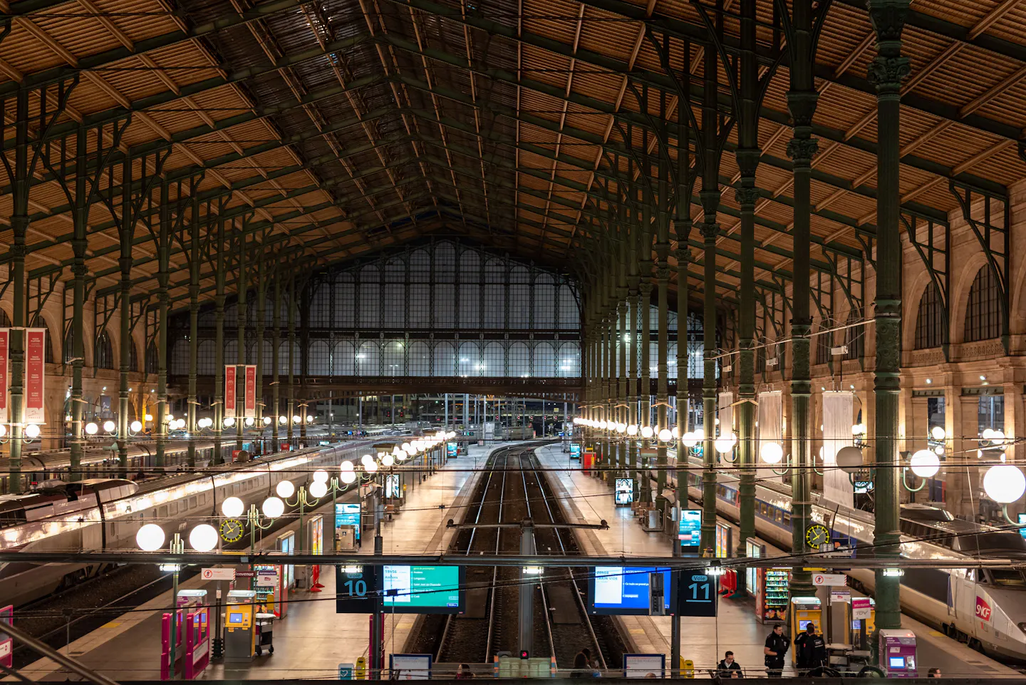 Train hall of Gare du Nord in Paris, with platforms and trains under the iron roof