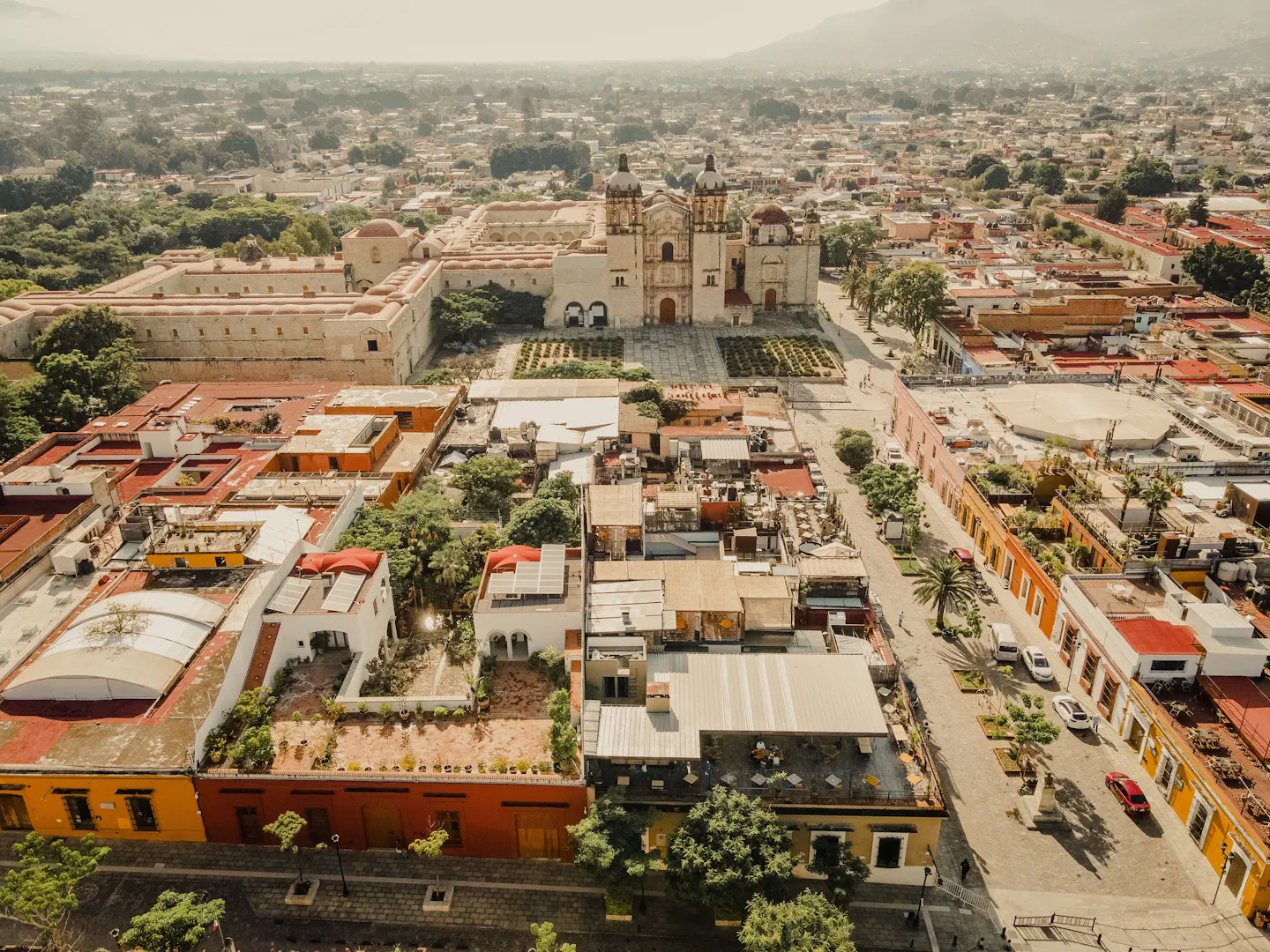 Aerial view over Oaxaca City’s historic center and church rooftops in warm sunshine