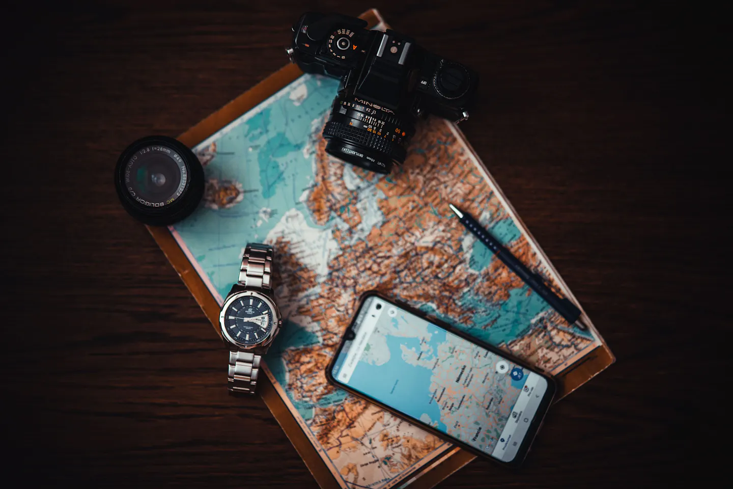 Travel essentials arranged with a map and camera
