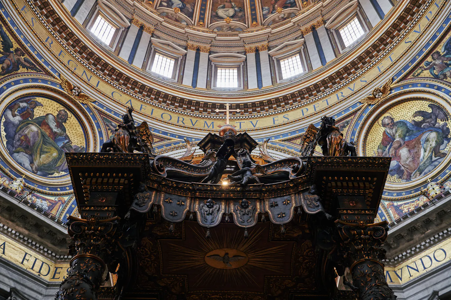 Bernini's bronze baldachin inside St Peter's Basilica beneath the gilded mosaics and windows of Michelangelo's dome