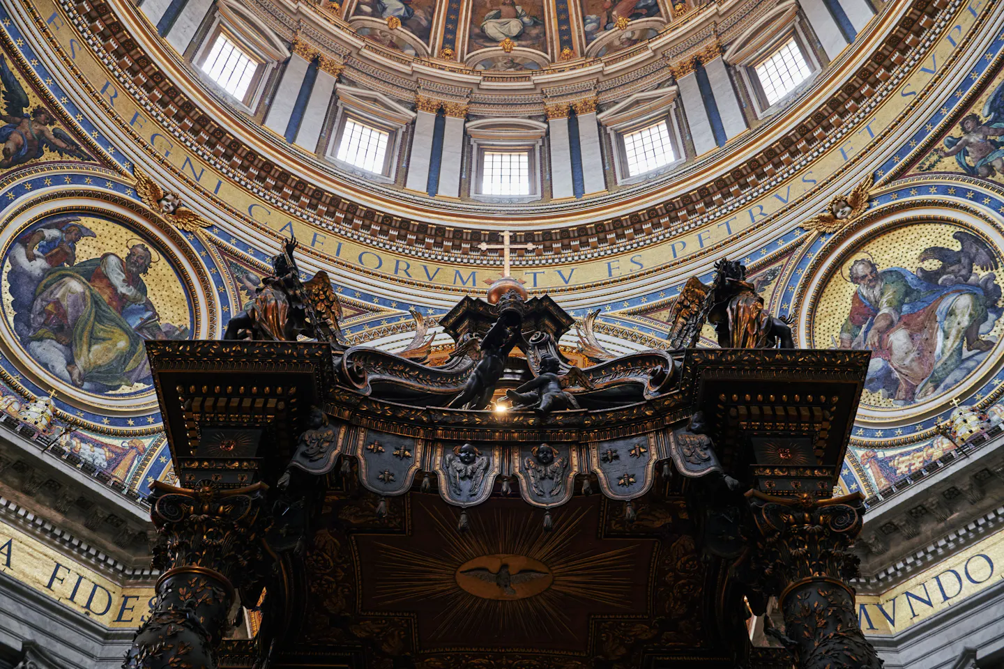 Bernini's bronze baldachin inside St Peter's Basilica beneath the gilded mosaics and windows of Michelangelo's dome