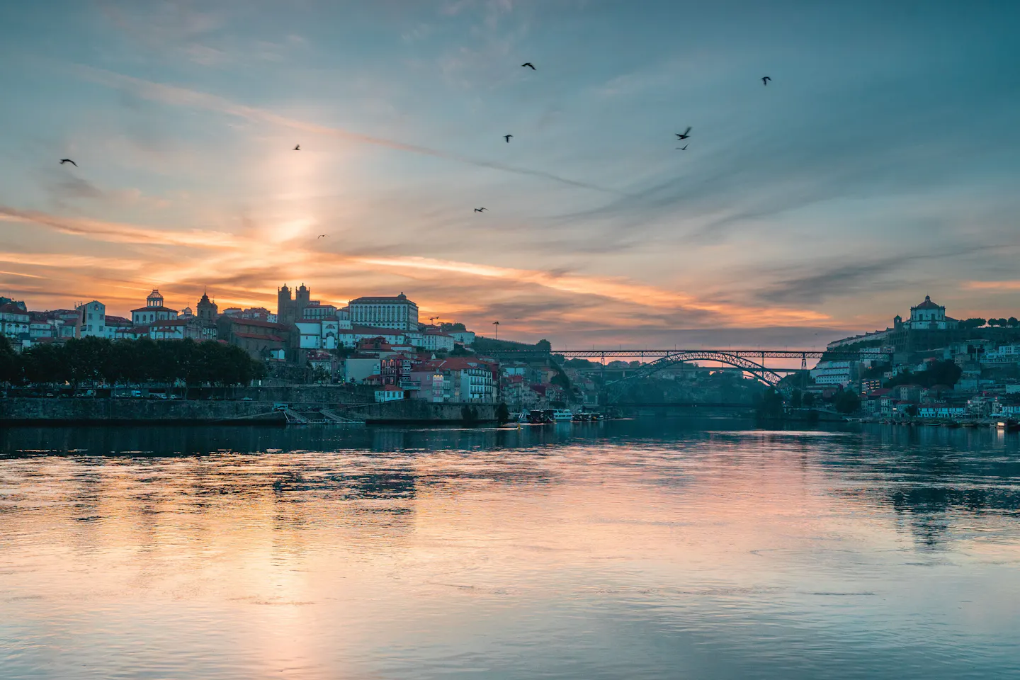 Sunset over the Douro at Porto, an iron bridge crossing towards the old town on the hillside