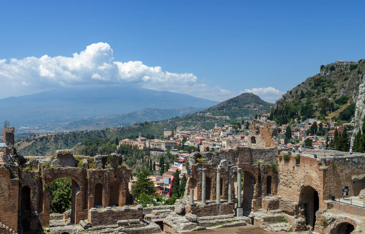 The ancient theatre at Taormina with the coast and Mount Etna behind it