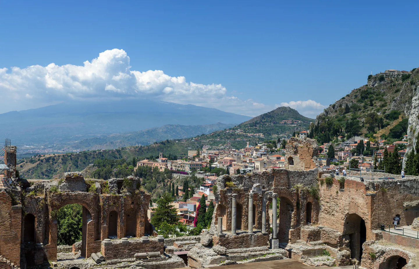 The ancient theatre at Taormina with the coast and Mount Etna behind it