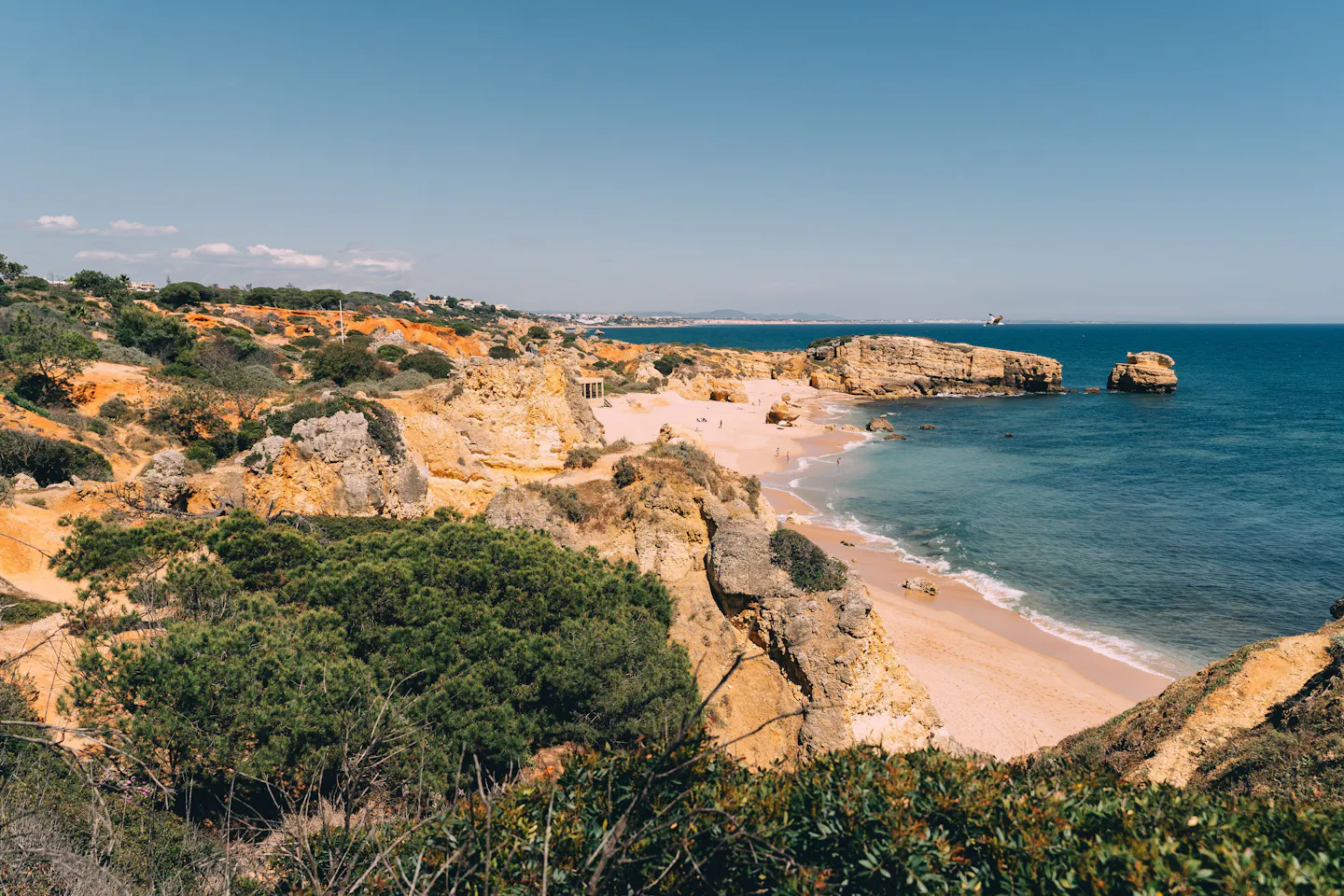 Golden sandstone cliffs around a small sandy cove on the Algarve coast