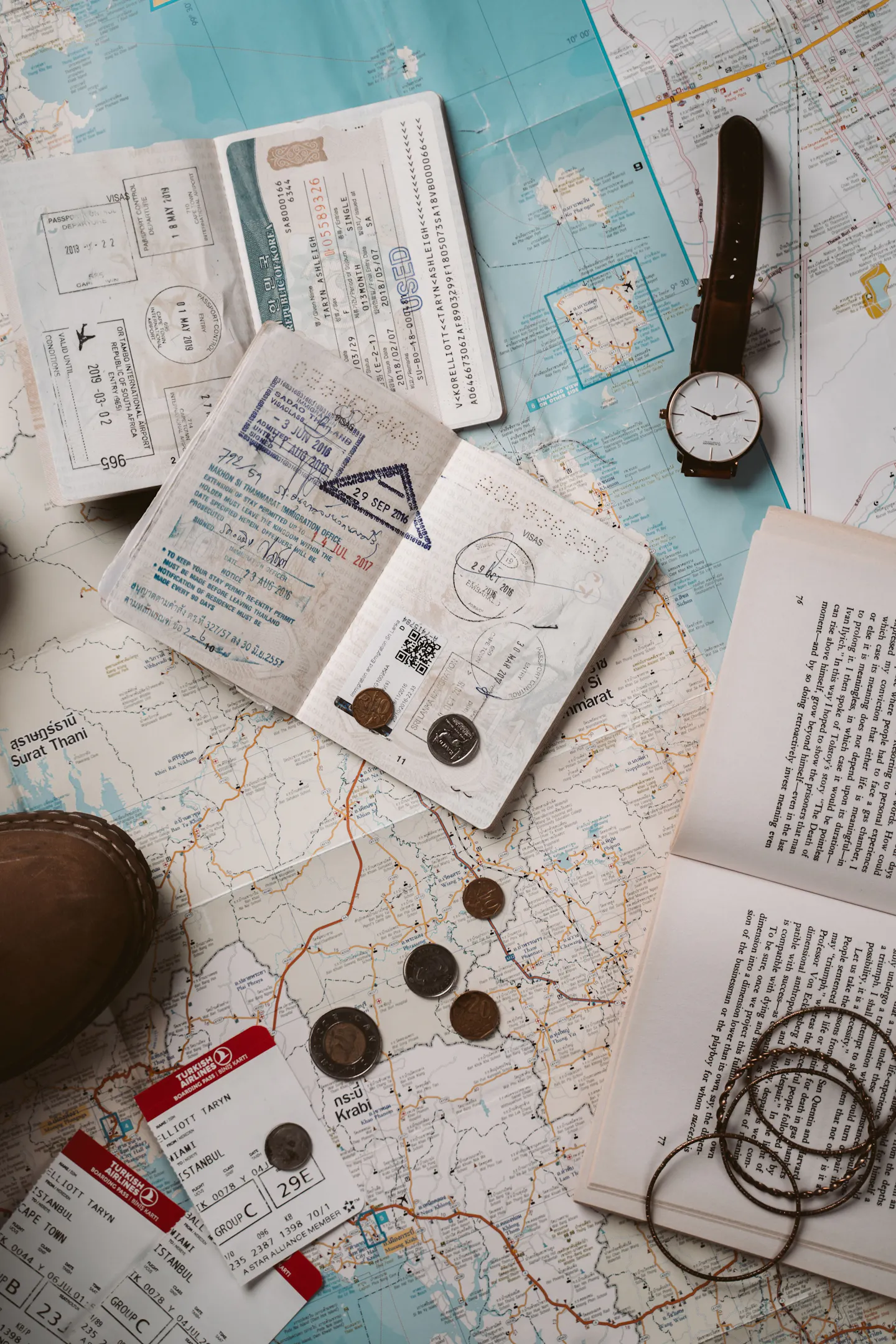 A passport, travel papers, tickets, and a map arranged for an international trip