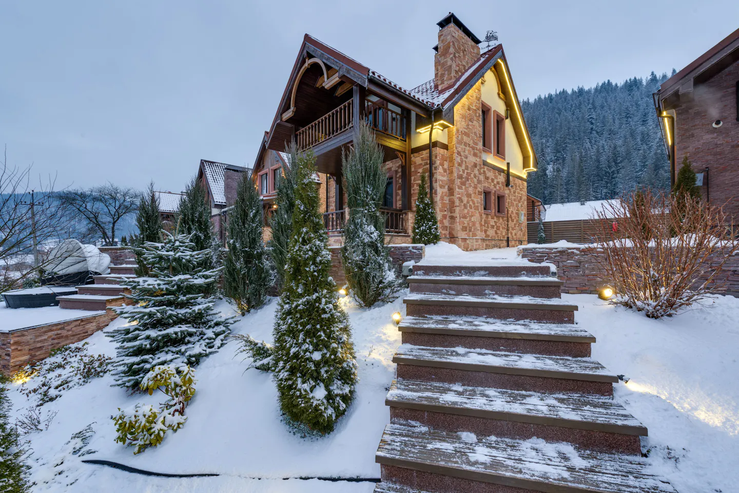 Luxury ski chalet in the European Alps, warmly lit amid fresh winter snow