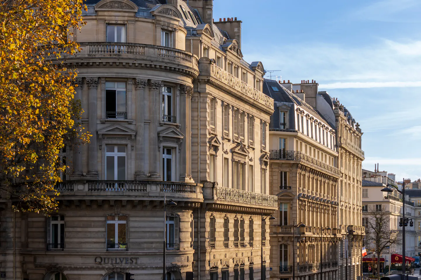 Haussmann stone facades and wrought-iron balconies in warm autumn light on Boulevard Saint-Germain