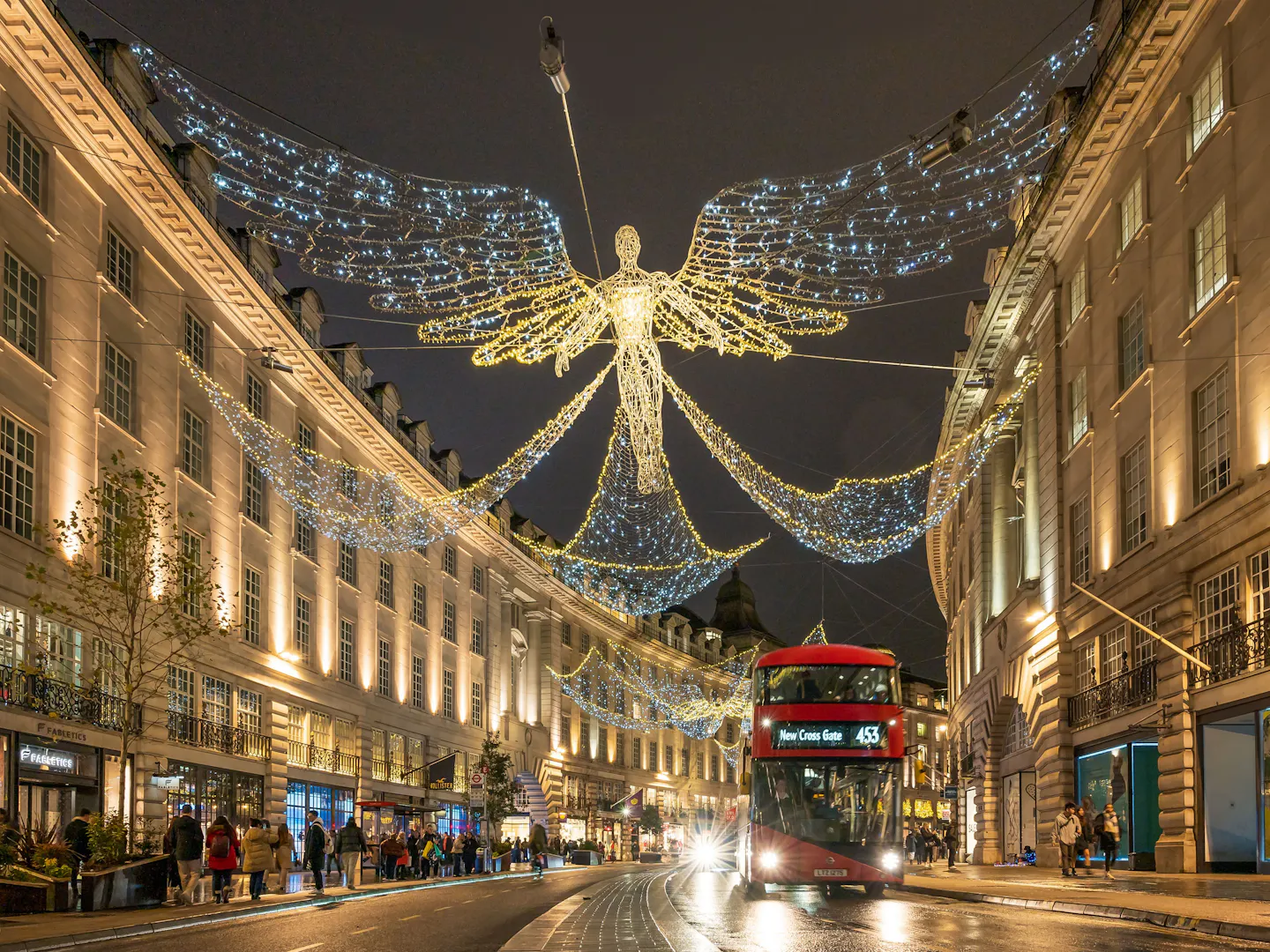 Regent Street, London, glowing with Christmas angel lights above a red double-decker bus