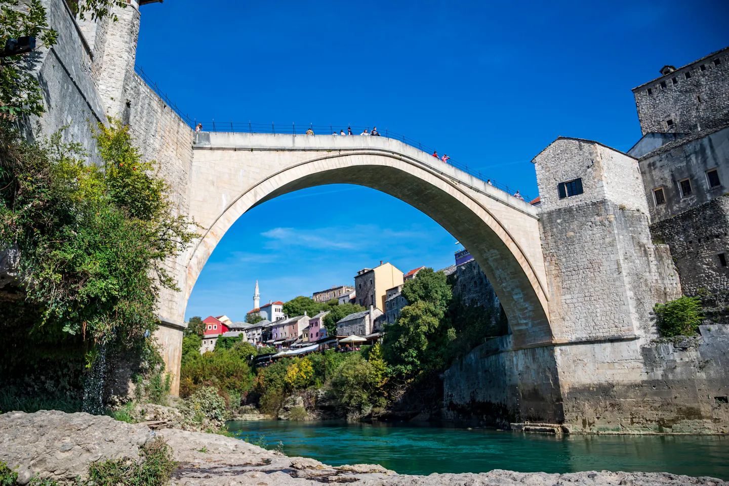 The stone arch of Mostar's Stari Most framing the old town and the turquoise Neretva below