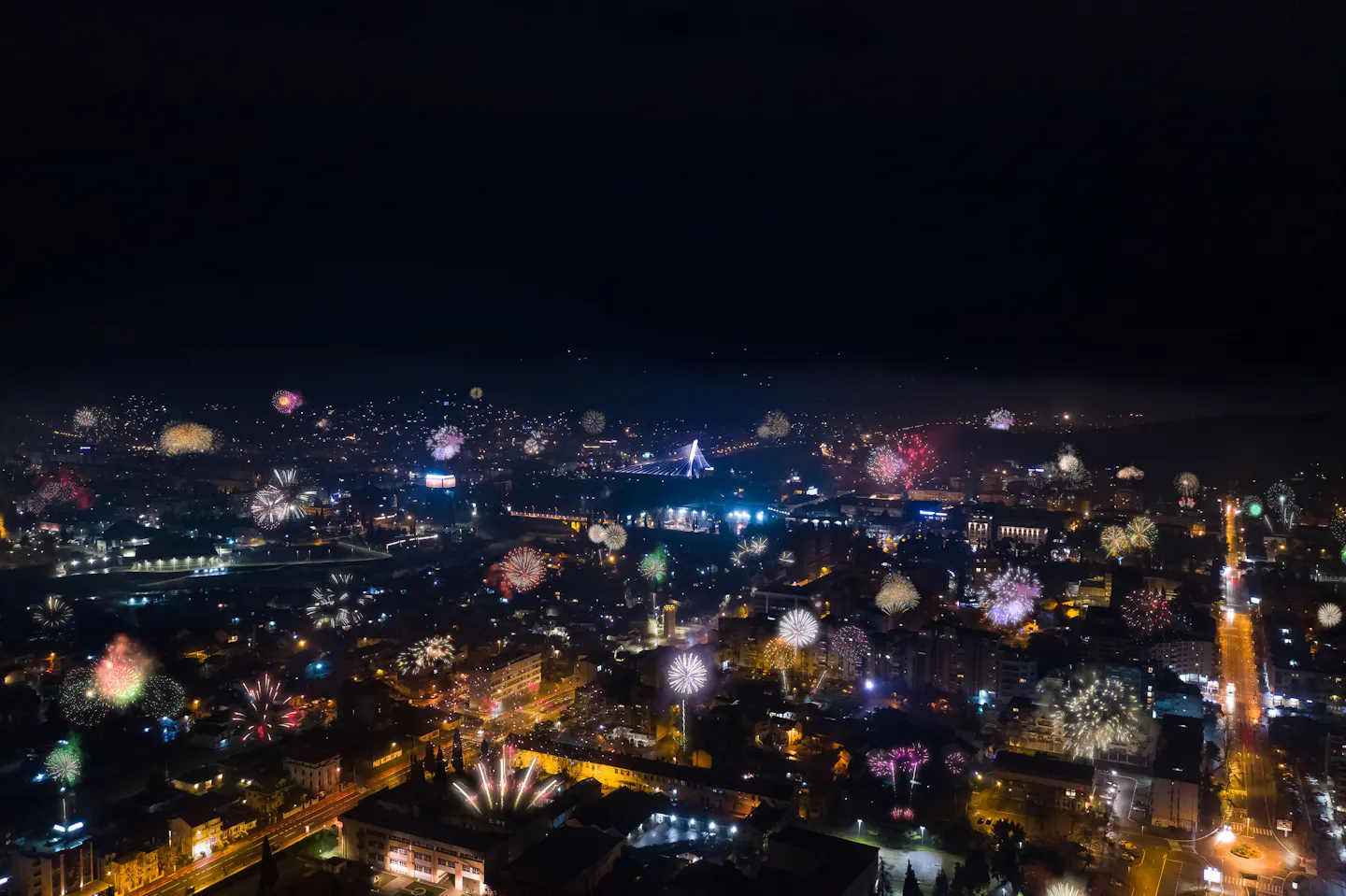 Fireworks bursting over a city lit up at night