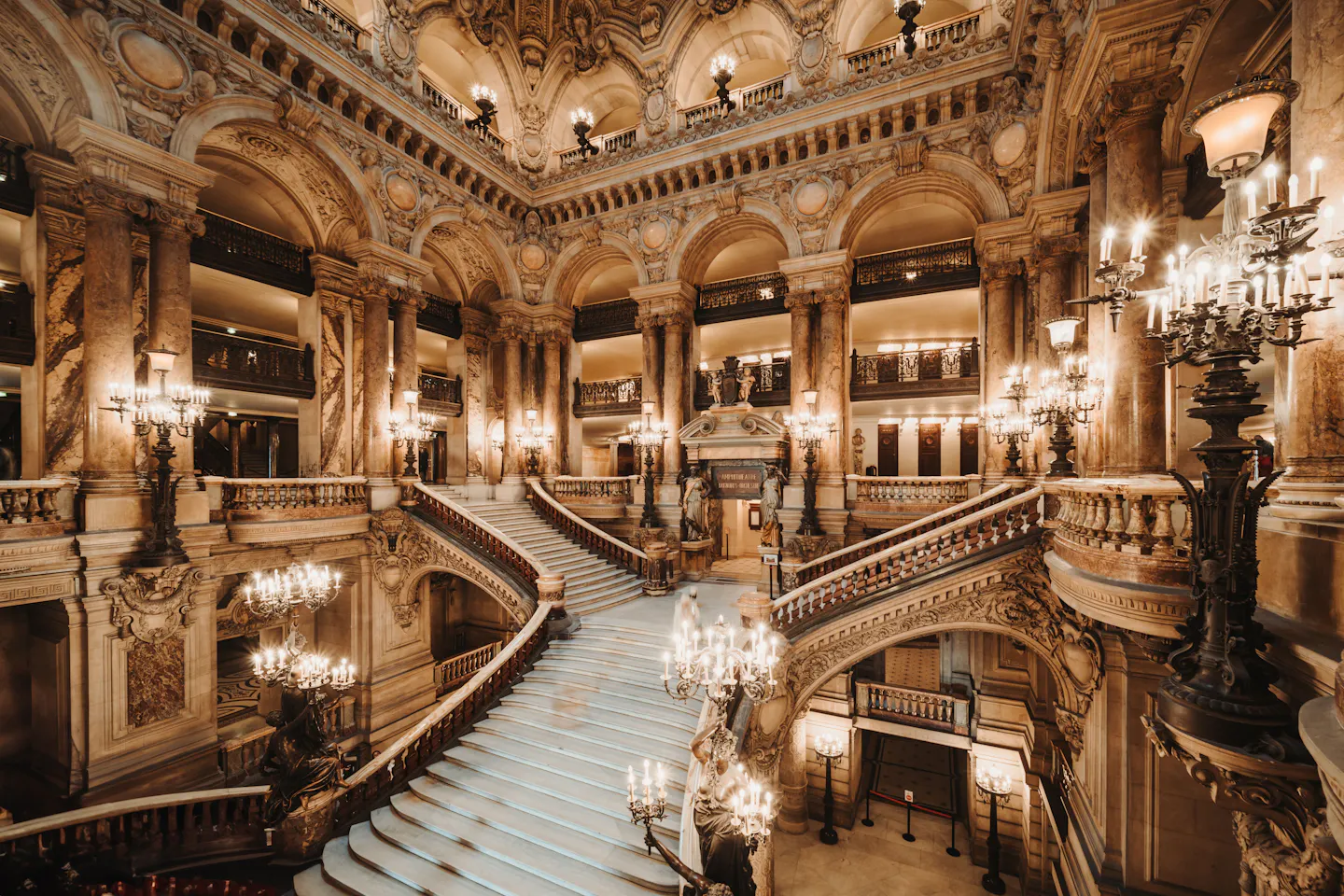 The marble grand staircase and chandeliers inside the Palais Garnier opera house