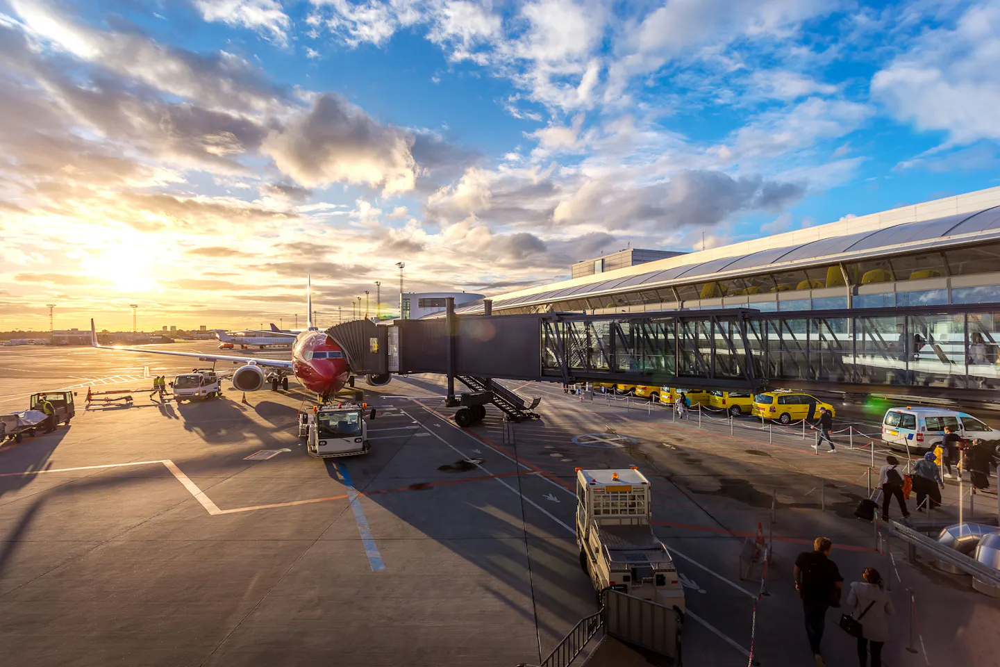 Passenger jet at a terminal jet bridge at sunset