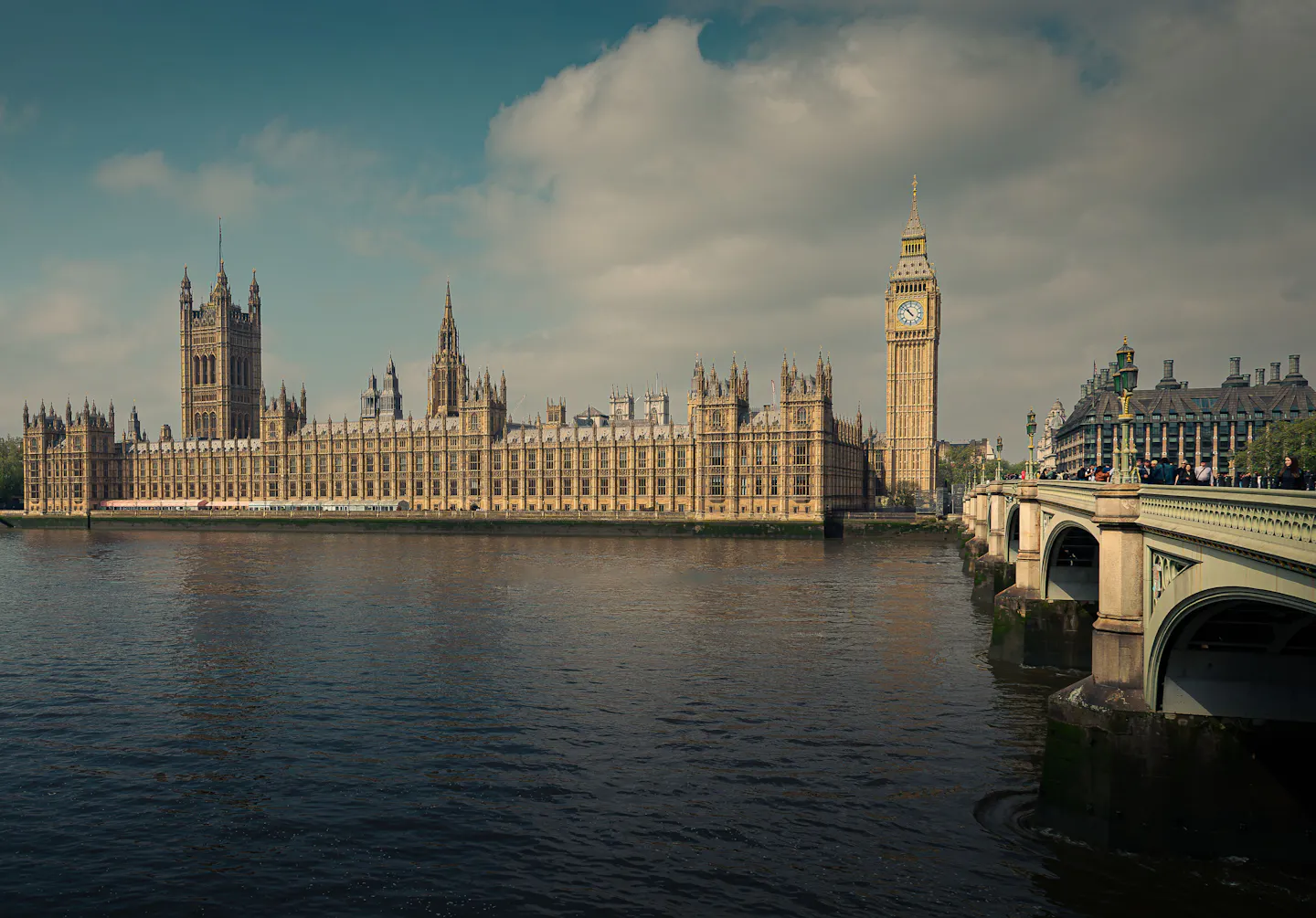 The Houses of Parliament and Big Ben above the Thames beside Westminster Bridge in afternoon light