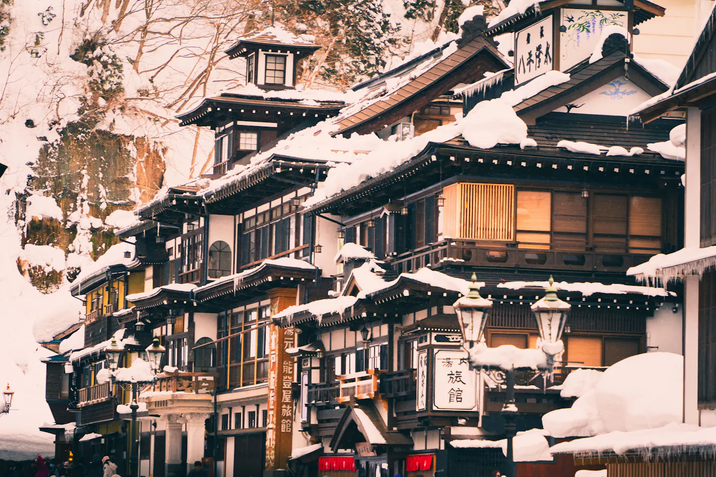 Traditional Japanese wooden inns under fresh snow in a hot-spring town