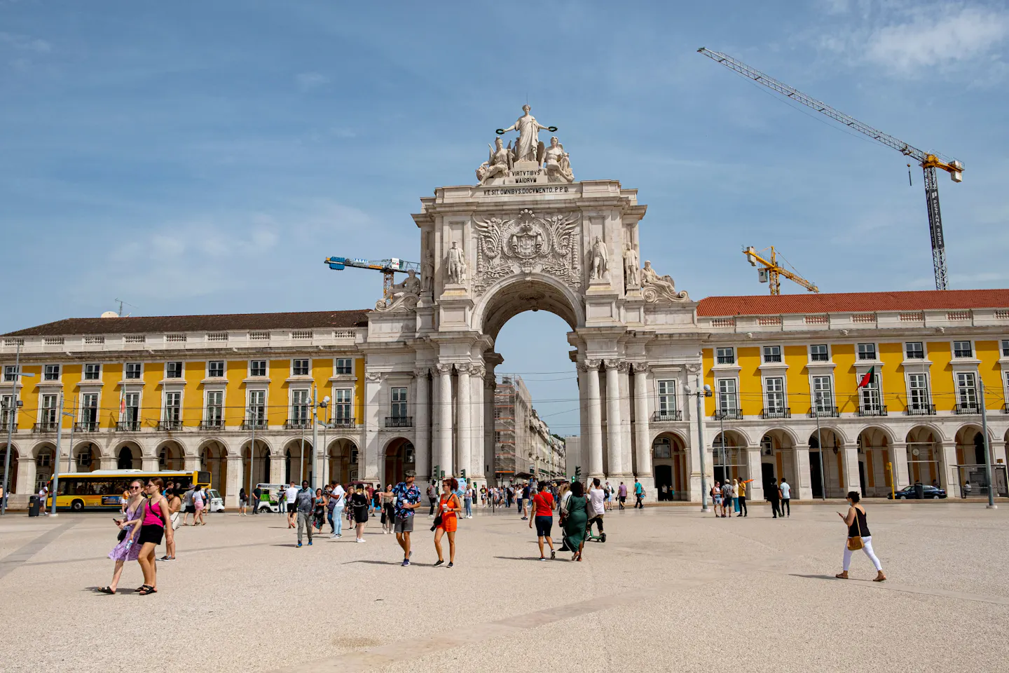 Visitors in Praça do Comércio beneath the Arco da Rua Augusta in Lisbon