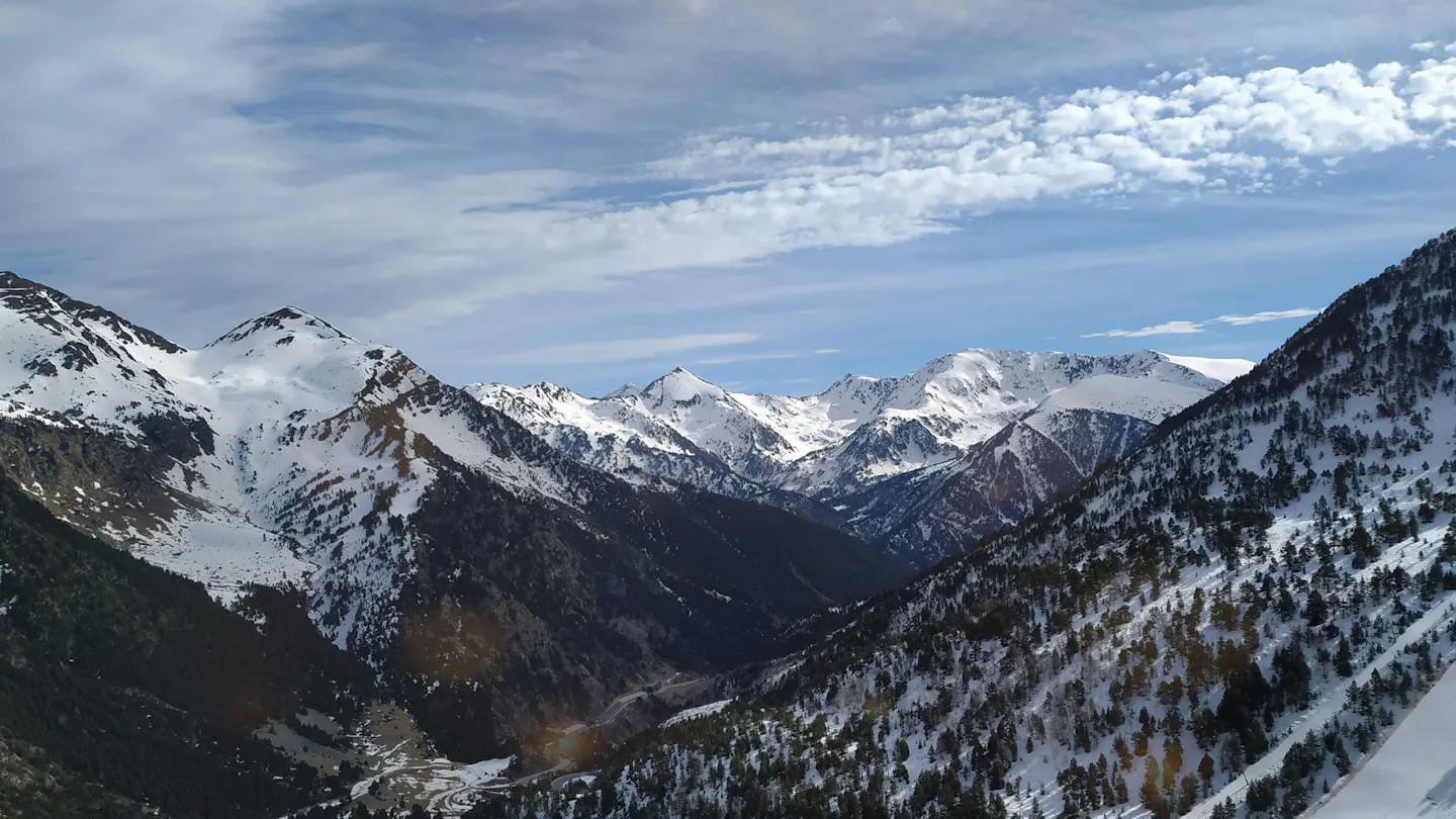 Snow-covered peaks in Ordino Arcalís, Andorra, beneath a bright blue sky