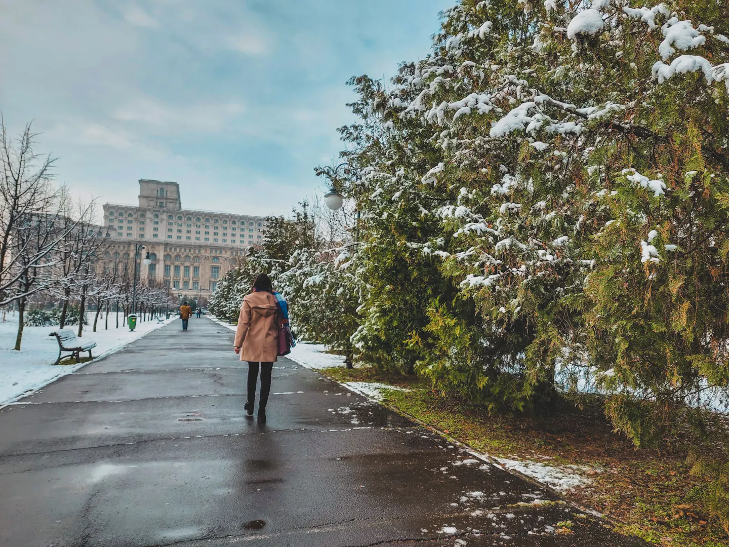Snowy park path leading toward the Palace of the Parliament in Bucharest