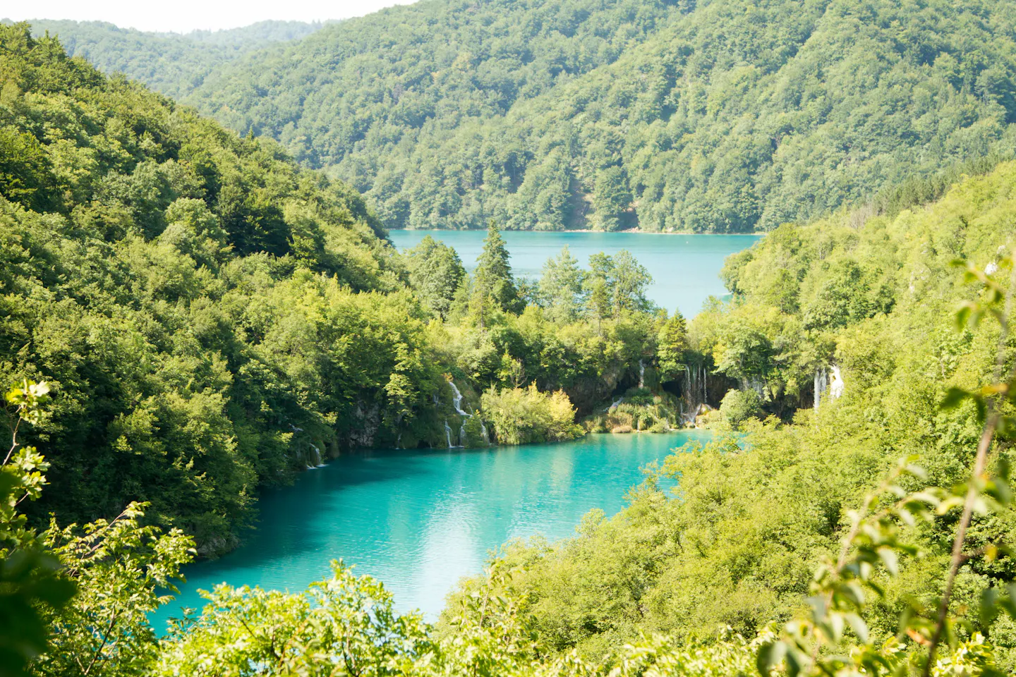Turquoise lakes and small waterfalls surrounded by forested hills at Plitvice Lakes, Croatia
